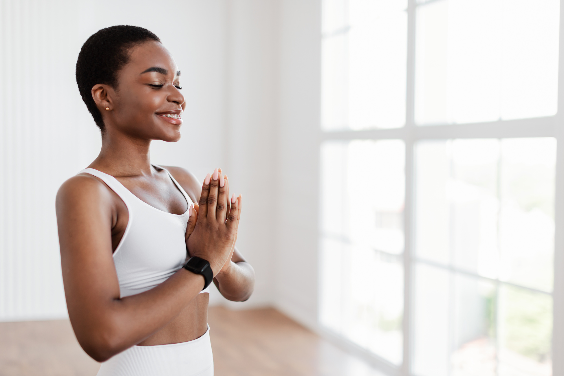 Black Woman Meditating in Prayer Pose with Closed Eyes